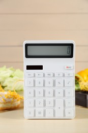 Photo of Calculator and food products on wooden table. Weight loss concept