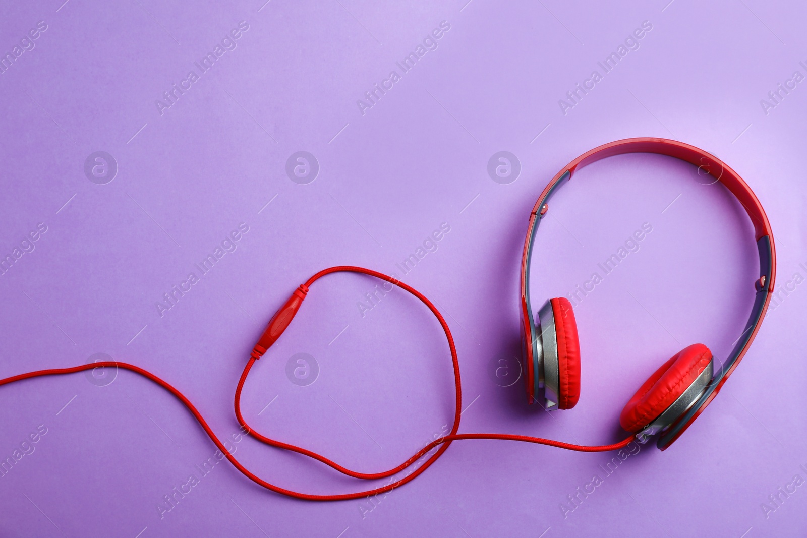 Photo of Stylish headphones on color background, top view. Space for text