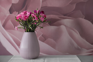 Photo of Vase with beautiful carnations on grey table. Space for text