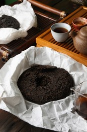 Photo of Aromatic pu-erh on wooden table. Fermented tea