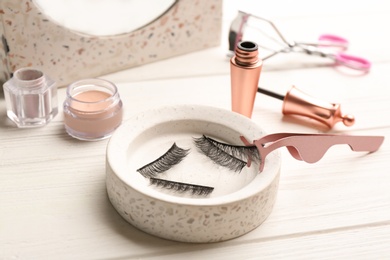 Magnetic eyelashes and accessories on white wooden table