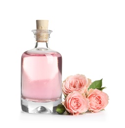 Photo of Bottle of rose essential oil and flowers isolated on white