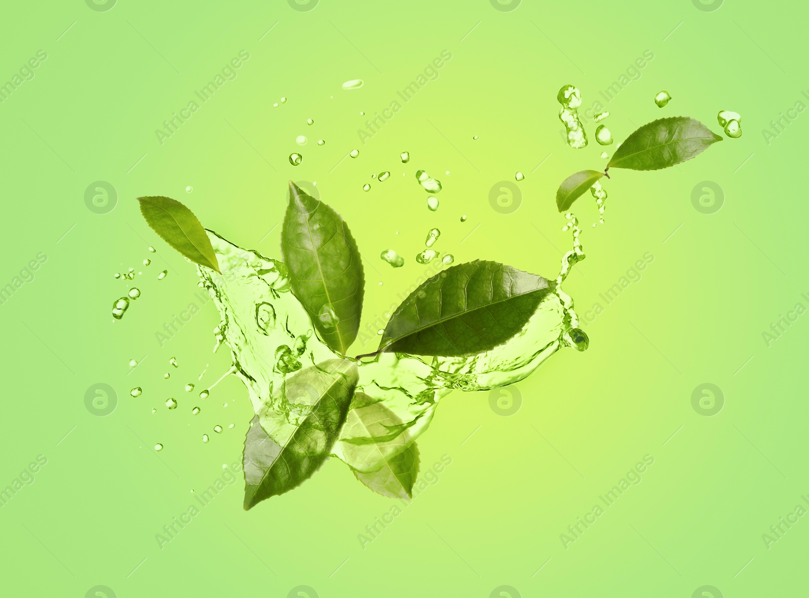 Image of Splashes of refreshing drink with leaves on pale green background. Green or matcha tea