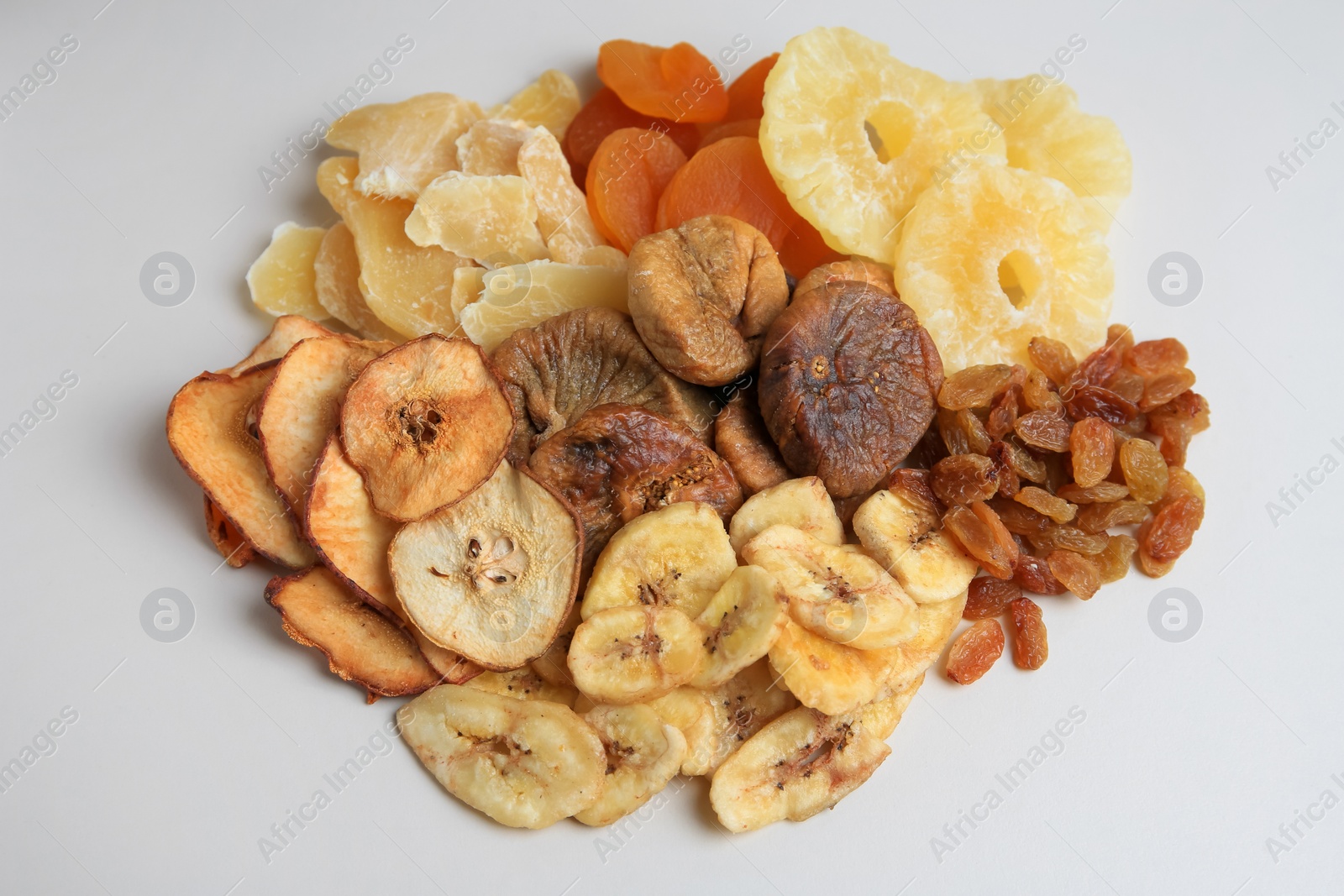 Photo of Pile of different dried fruits on white background, top view