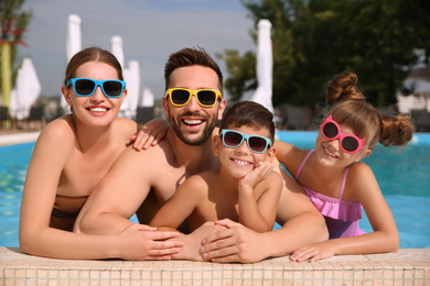 Happy family in swimming pool on sunny day