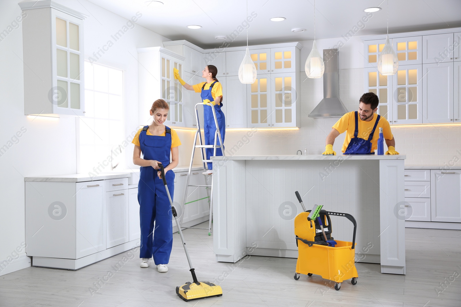 Photo of Team of professional janitors cleaning modern kitchen