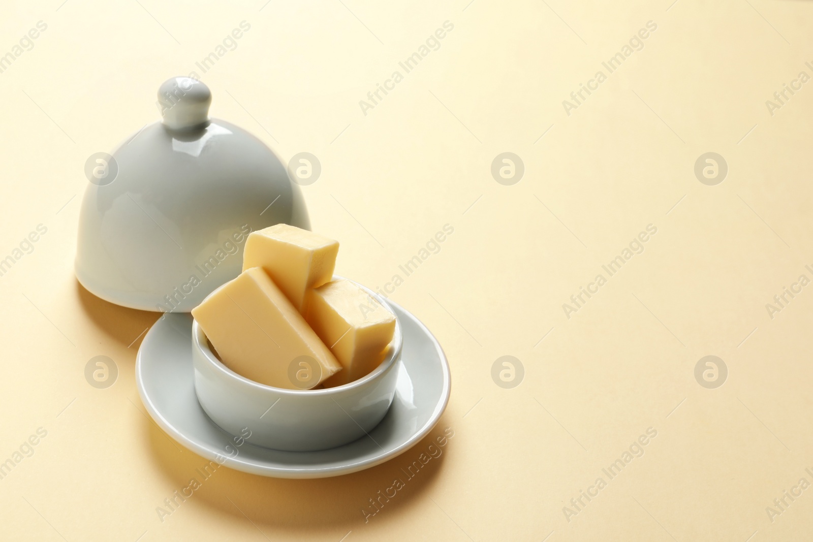 Photo of Dish with fresh butter on color background. Space for text