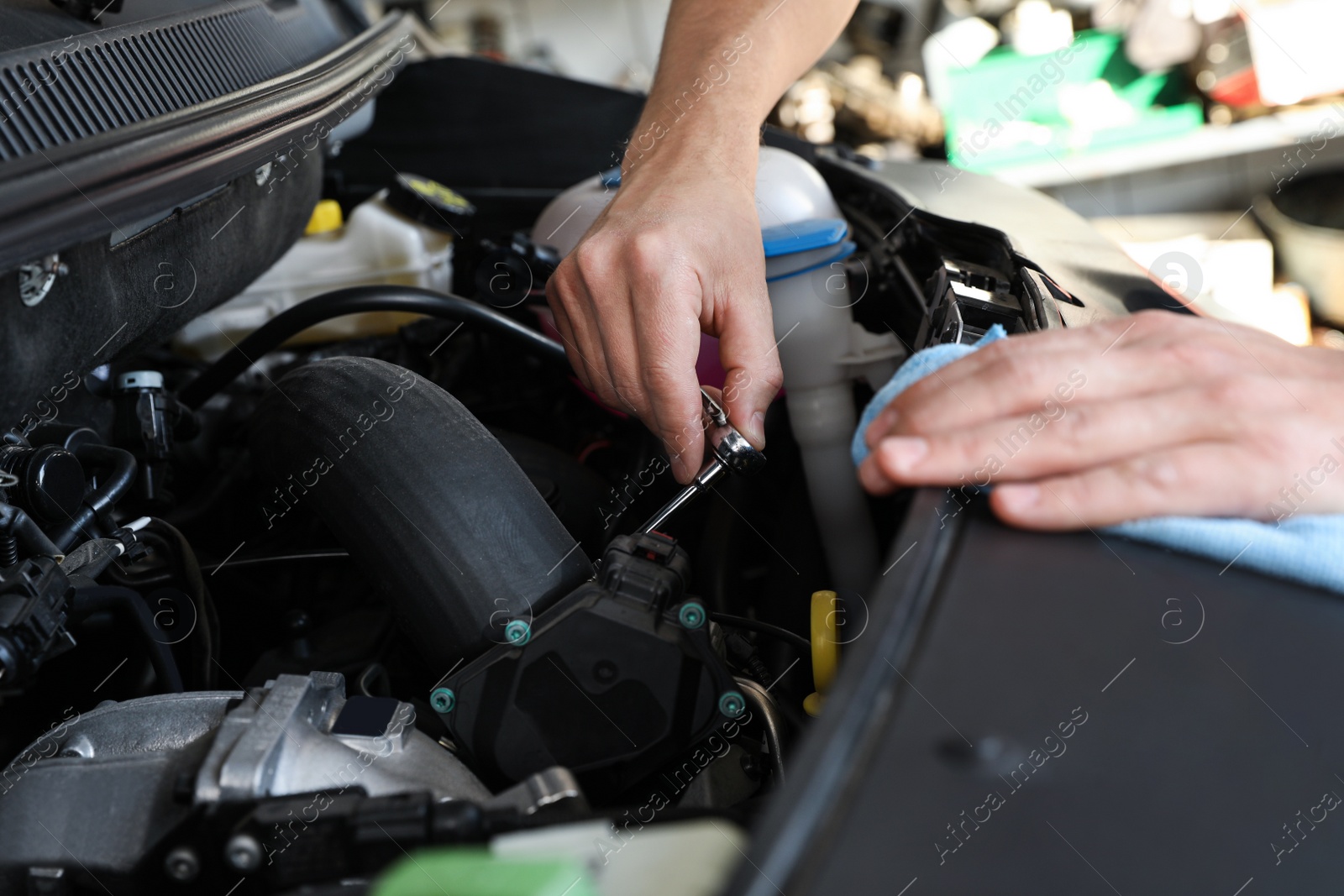 Photo of Professional auto mechanic fixing modern car in service center, closeup