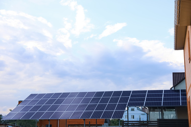 Photo of Modern solar panels installed on backyard of cottage
