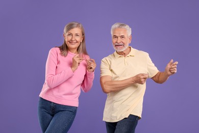 Photo of Senior couple dancing together on purple background