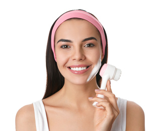 Photo of Young woman using facial cleansing brush on white background. Washing accessory