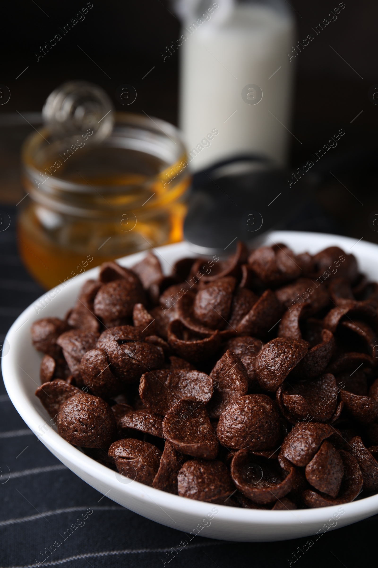 Photo of Breakfast cereal. Chocolate corn flakes in bowl on table, closeup
