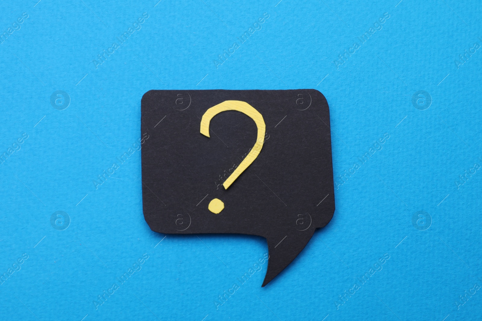 Photo of Paper speech bubble with question mark on light blue background, top view