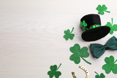 Photo of Flat lay composition with leprechaun hat on white wooden table, space for text. St Patrick's Day celebration