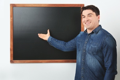 Portrait of male teacher near chalkboard in classroom