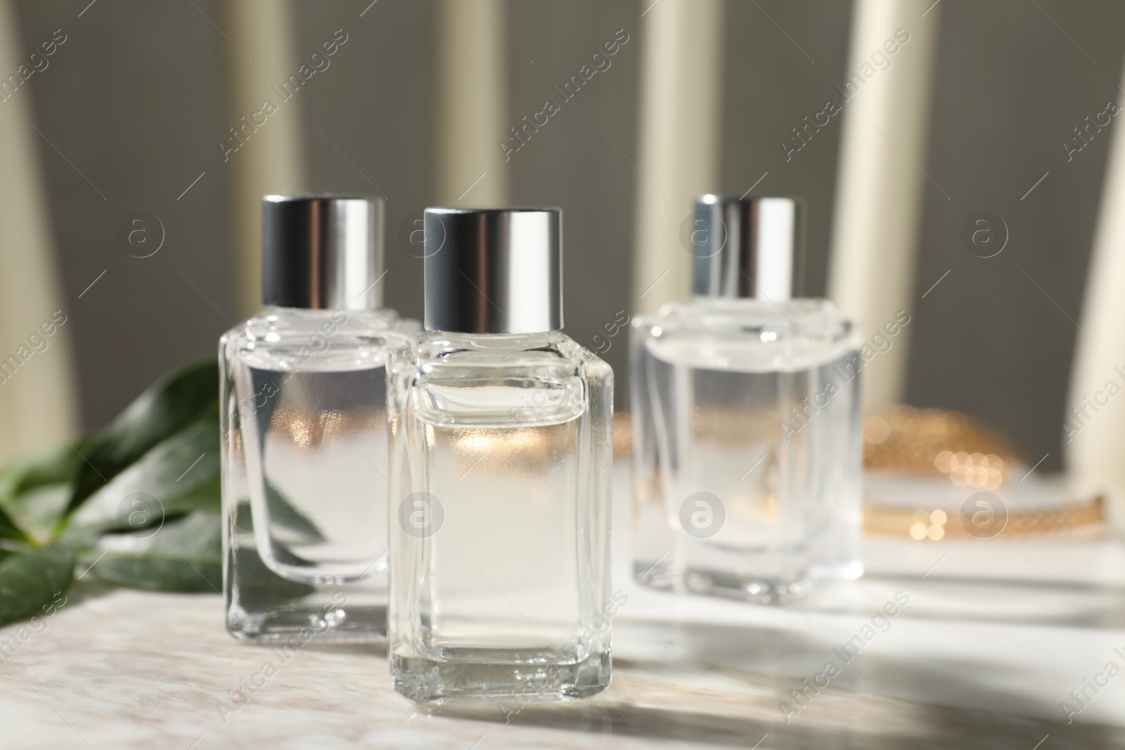 Photo of Bottles of essential oil on white marble table, closeup