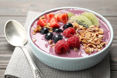 Delicious acai smoothie with fruits served on grey wooden table, closeup