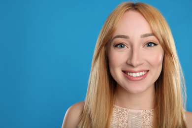 Photo of Portrait of beautiful young woman with blonde hair on blue background