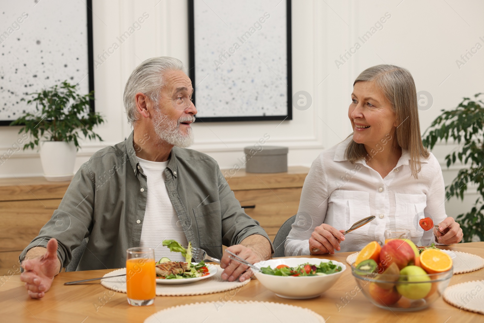 Photo of Happy senior couple having dinner at home