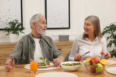 Happy senior couple having dinner at home