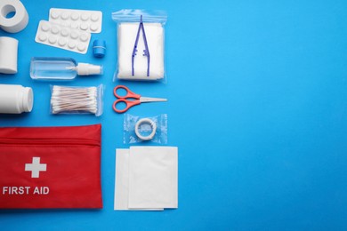 Photo of Flat lay composition with first aid kit on light blue background. Space for text