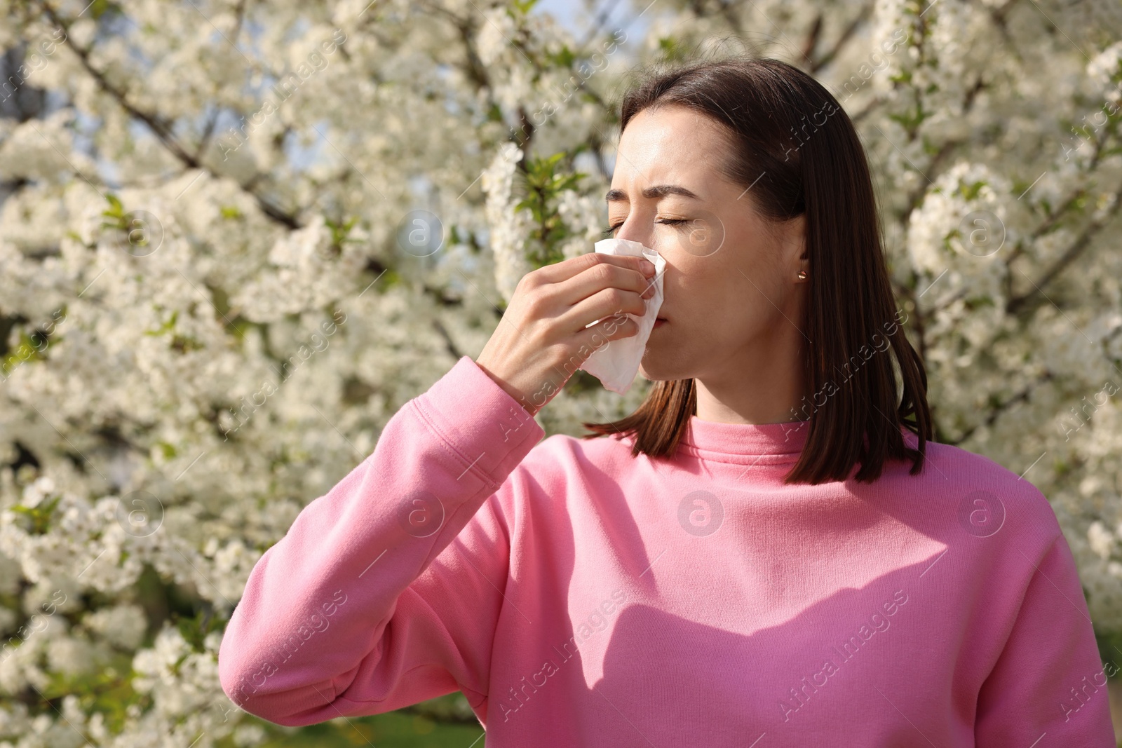 Photo of Woman with napkin suffering from seasonal allergy on spring day