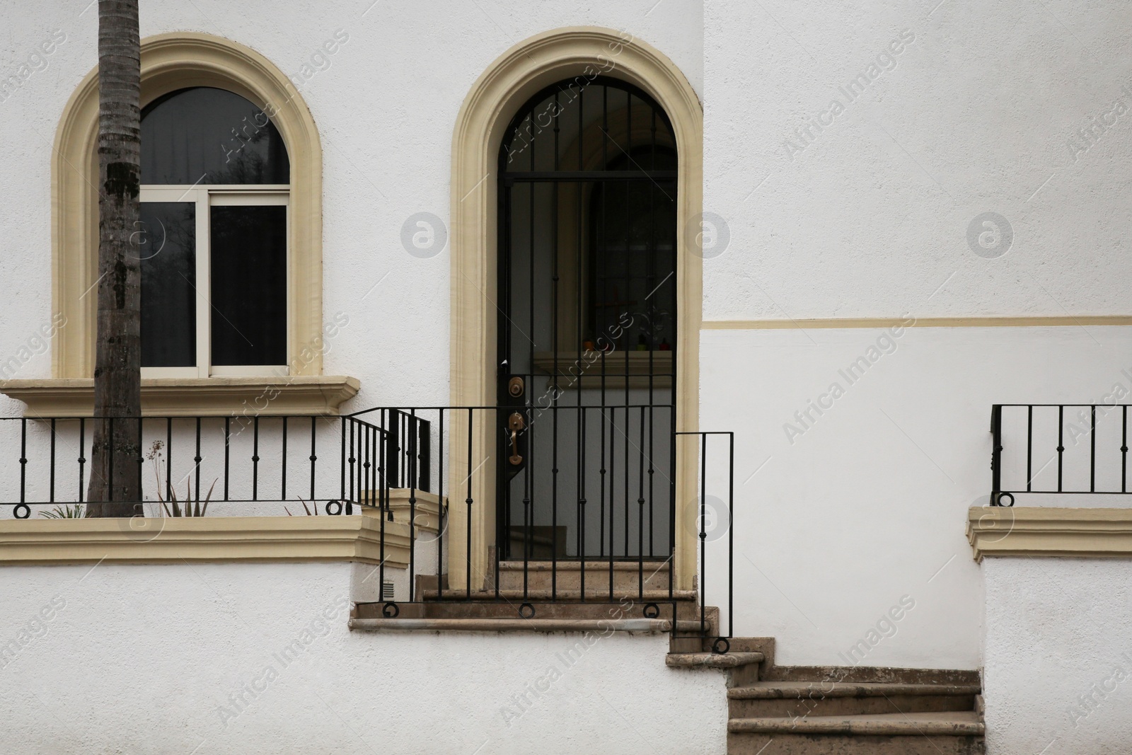 Photo of Entrance of residential house with door, potted plants and window