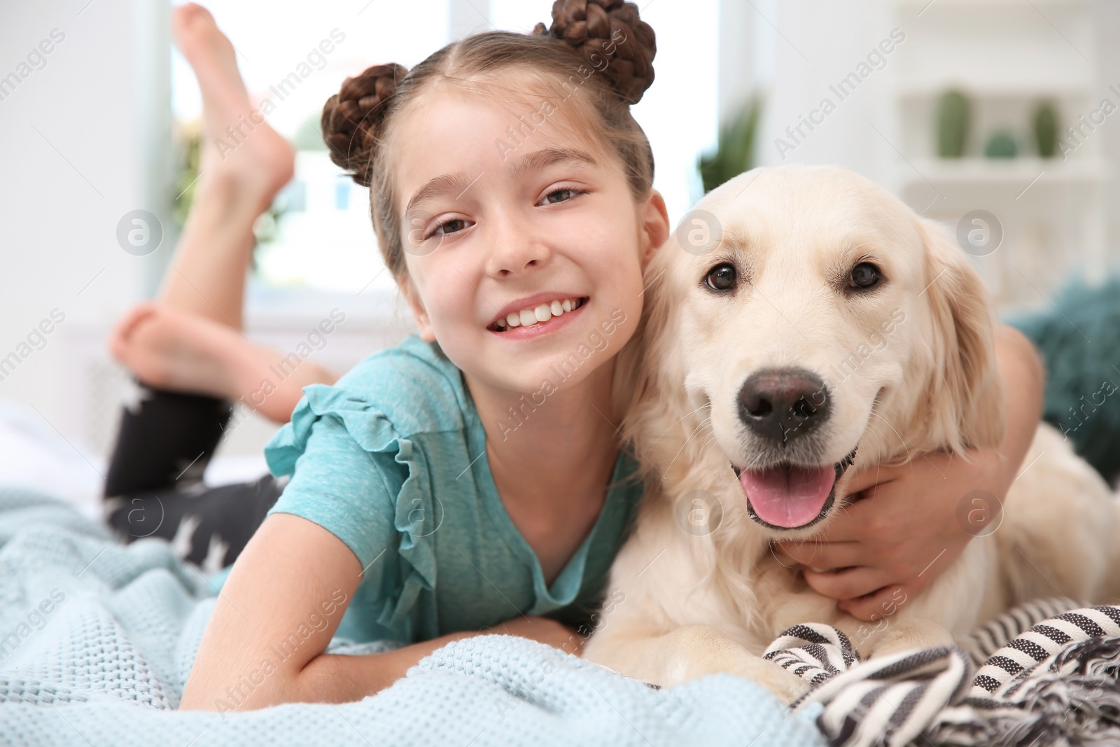 Photo of Cute little child with her pet on bed at home