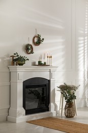 Stylish room with beautiful fireplace and eucalyptus branches