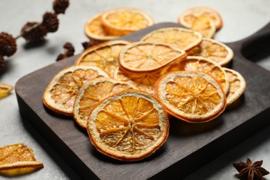 Photo of Dry orange slices and anise stars on light grey table, closeup