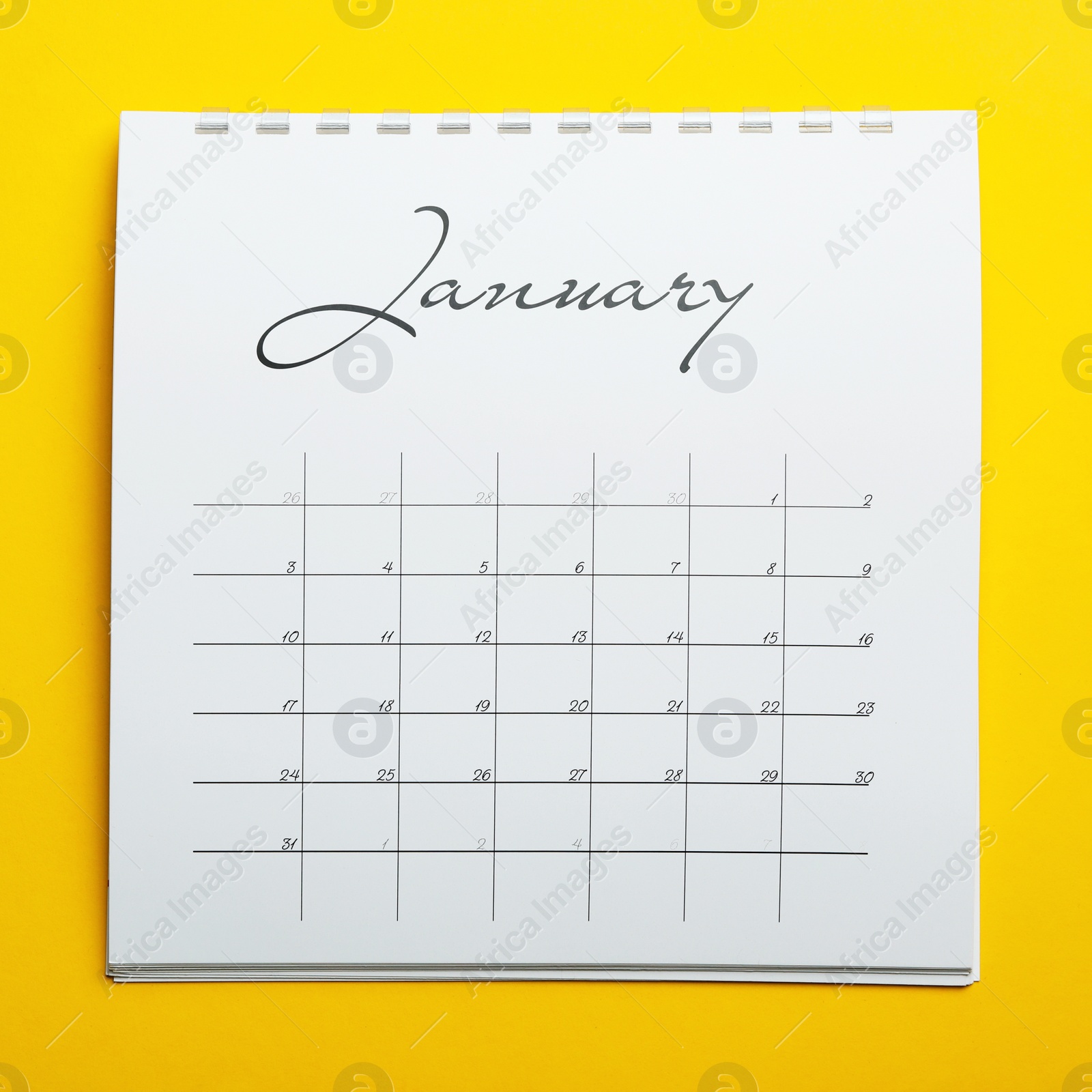 Photo of January calendar on yellow background, top view