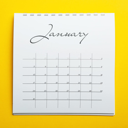Photo of January calendar on yellow background, top view