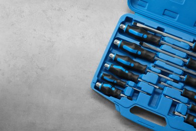 Photo of Set of screwdrivers in open toolbox on light table, top view. Space for text