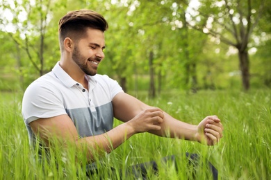 Photo of Young man scratching hand outdoors. Seasonal allergy