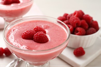 Glass of delicious raspberry mousse on table, closeup view