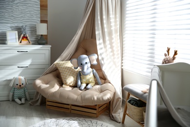 Photo of Comfortable armchair in modern baby room interior