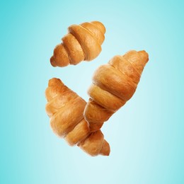 Image of Golden croissants falling on cyan gradient background