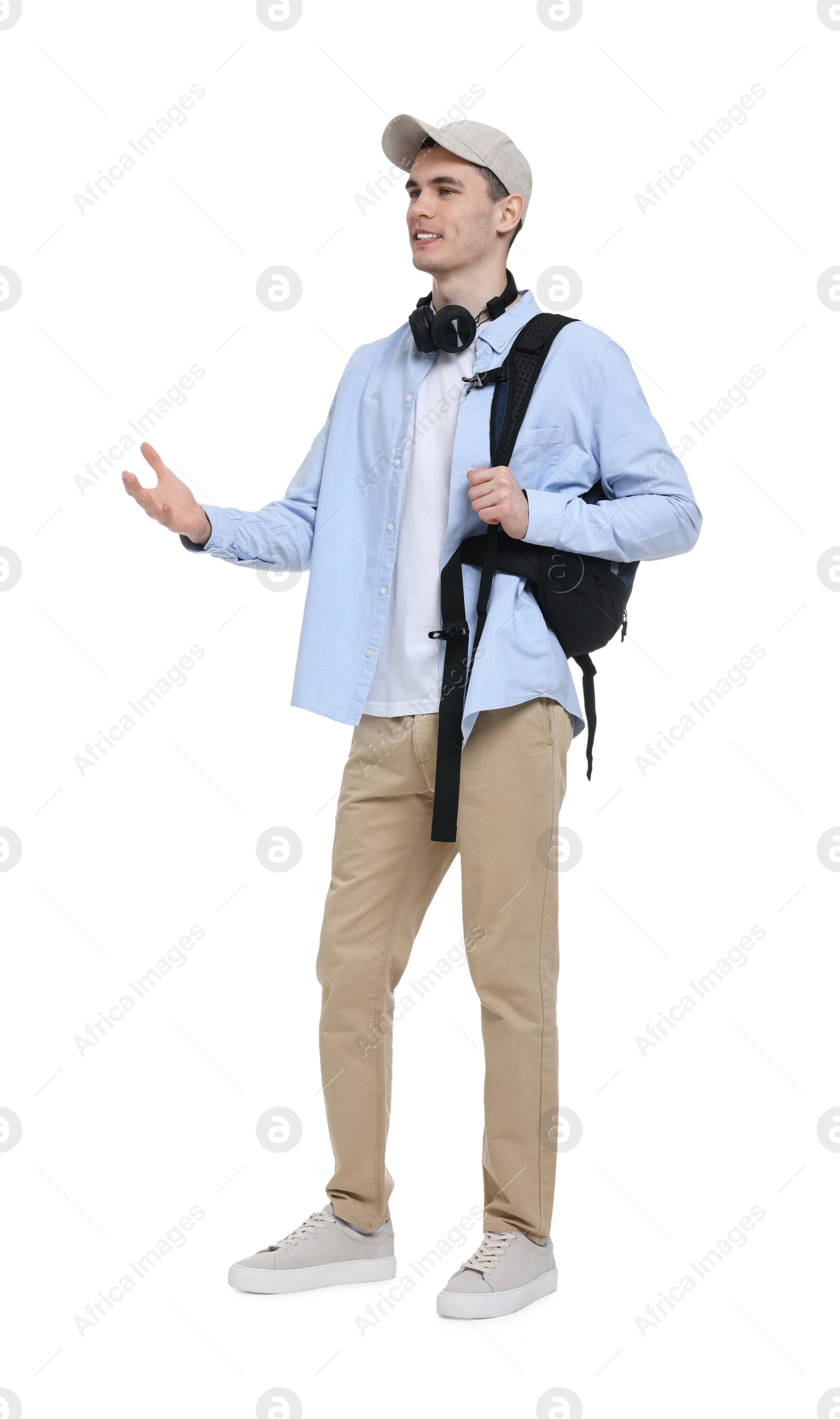 Photo of Young man with cap, headphones and backpack on white background