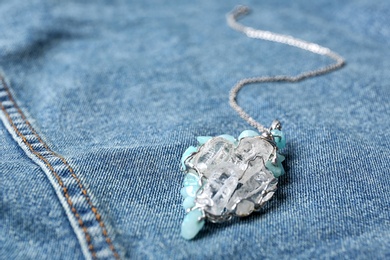 Beautiful silver pendent with pure quartz gemstones on blue fabric. Space for text