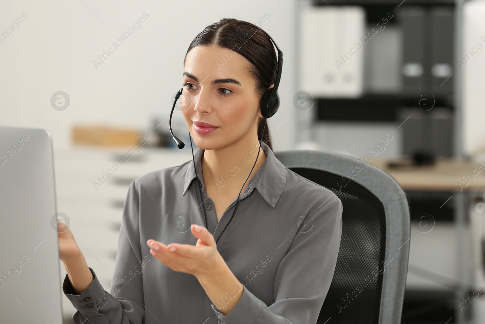 Photo of Hotline operator with headset working in office