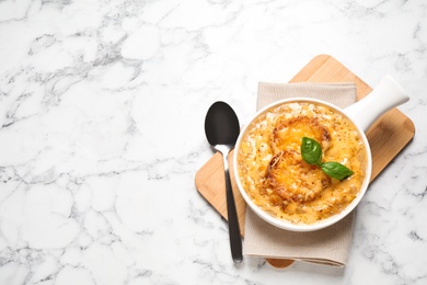 Tasty homemade french onion soup served on white marble table, flat lay. Space for text