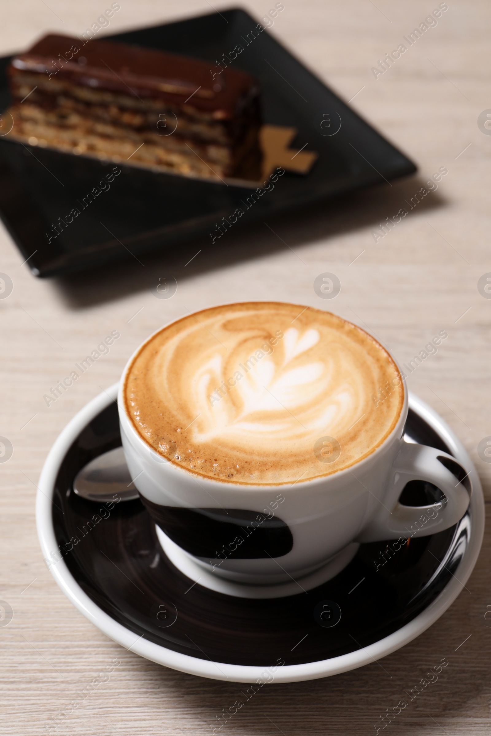 Photo of Cup of aromatic coffee and dessert on wooden table