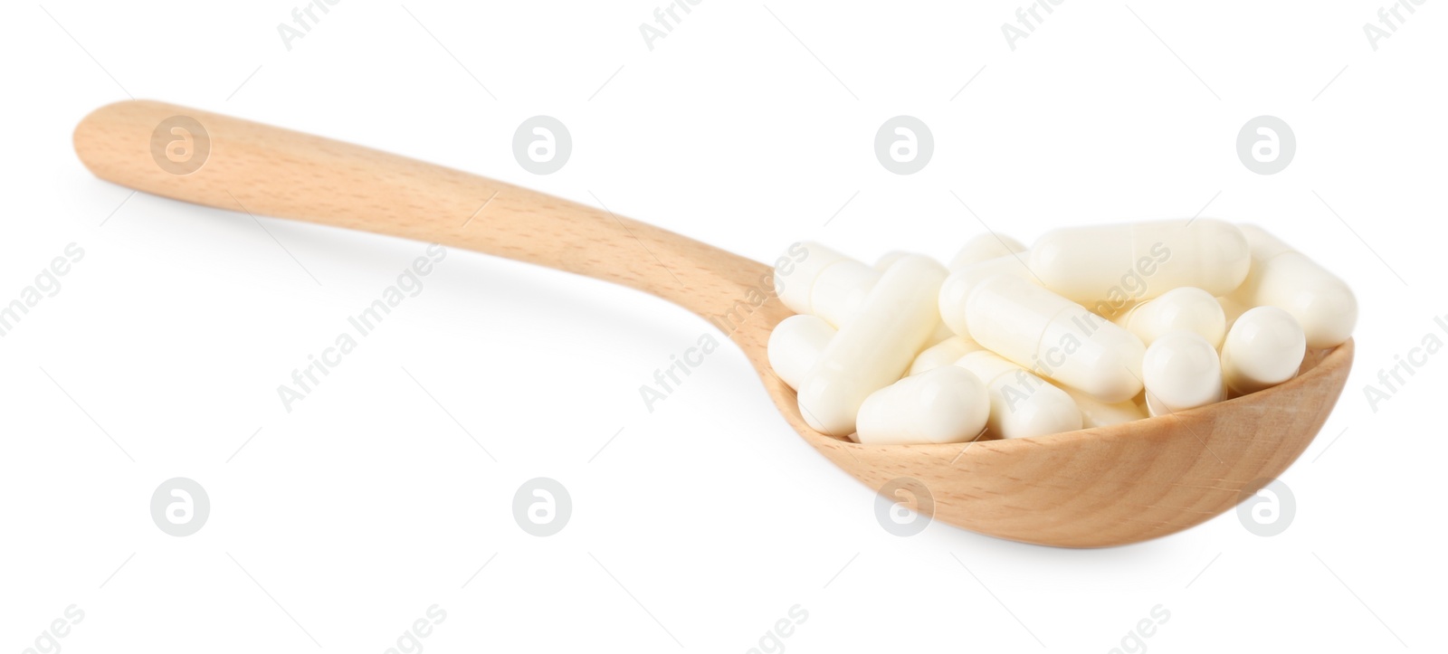 Photo of Vitamin capsules in wooden spoon isolated on white