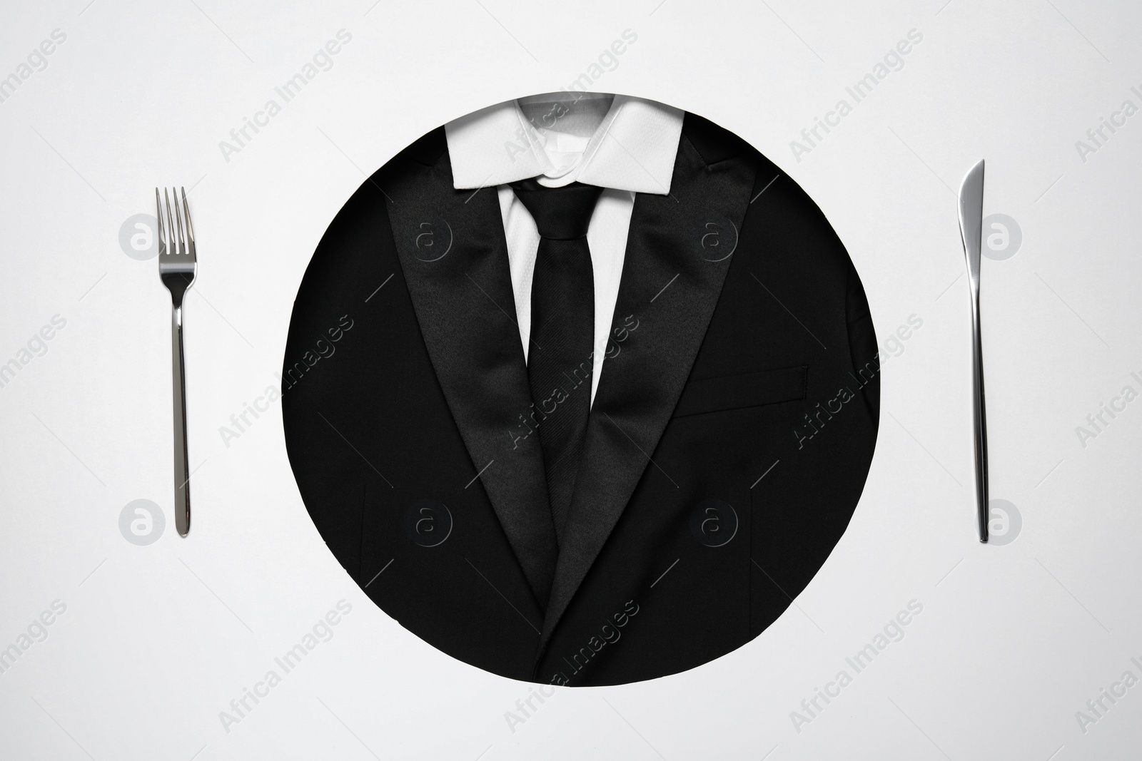 Photo of Creative business lunch layout. Hole with suit as plate and cutlery on white background