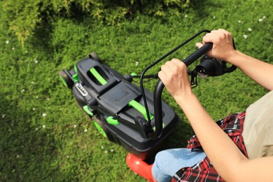 Photo of Woman cutting grass with lawn mower in garden, above view