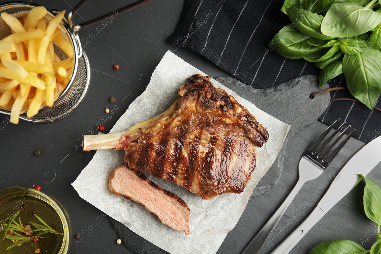 Image of Tasty grilled steak served on black table, flat lay