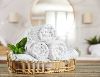 Image of Fresh towels on wooden table in bathroom