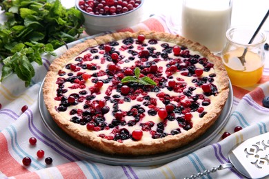 Photo of Delicious currant pie and fresh berries on kitchen towel