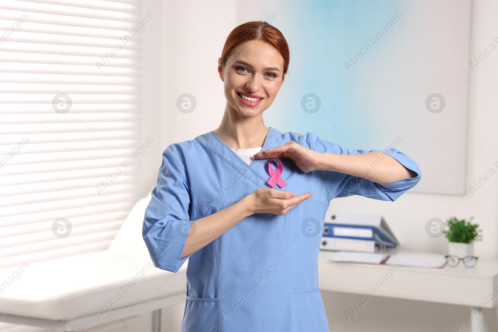 Photo of Mammologist with pink ribbon in hospital. Breast cancer awareness