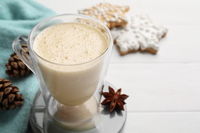Photo of Tasty eggnog, cookies and anise star on white wooden table, closeup. Space for text